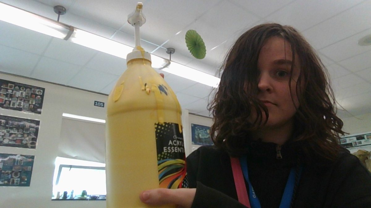 Zander (me) holding a large bottle of yellow acrylic paint.