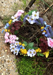 A close-up picture of a spring-related wreath I made, which is sitting on my front lawn. All flowers are artificial and were purchased from Hobby Lobby.