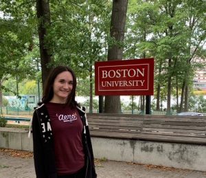 Andrea taking a picture in front of the Boston University sign when she went on a campus tour.
