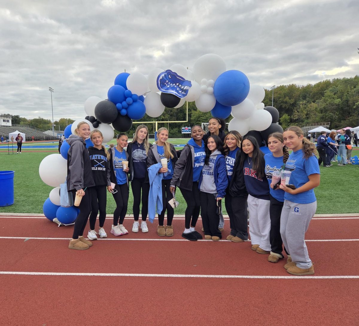 Some Gateway students posing in front of the balloon arch welcoming people to Gator day