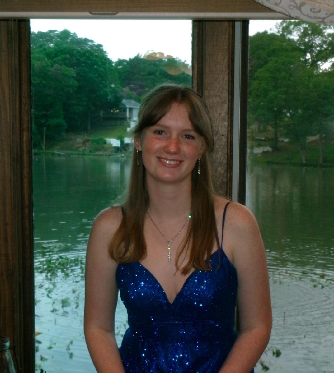 Abria Joshua posing in front of a window at her senior prom